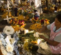 Notte al cimitero tra teschi di zucchero e candele accese