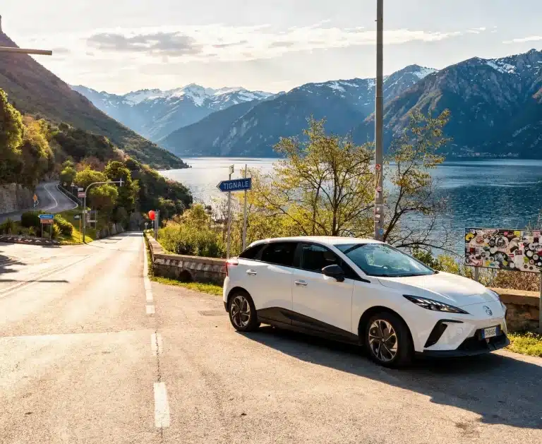 Momento di pausa durante un road trip in famiglia: un'auto elettrica moderna in sosta panoramica vicino a lago di Garda.